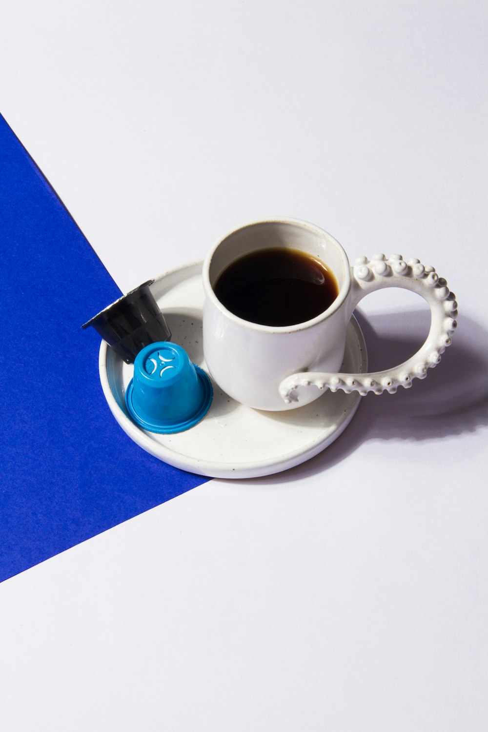 white ceramic mug with coffee on white tray