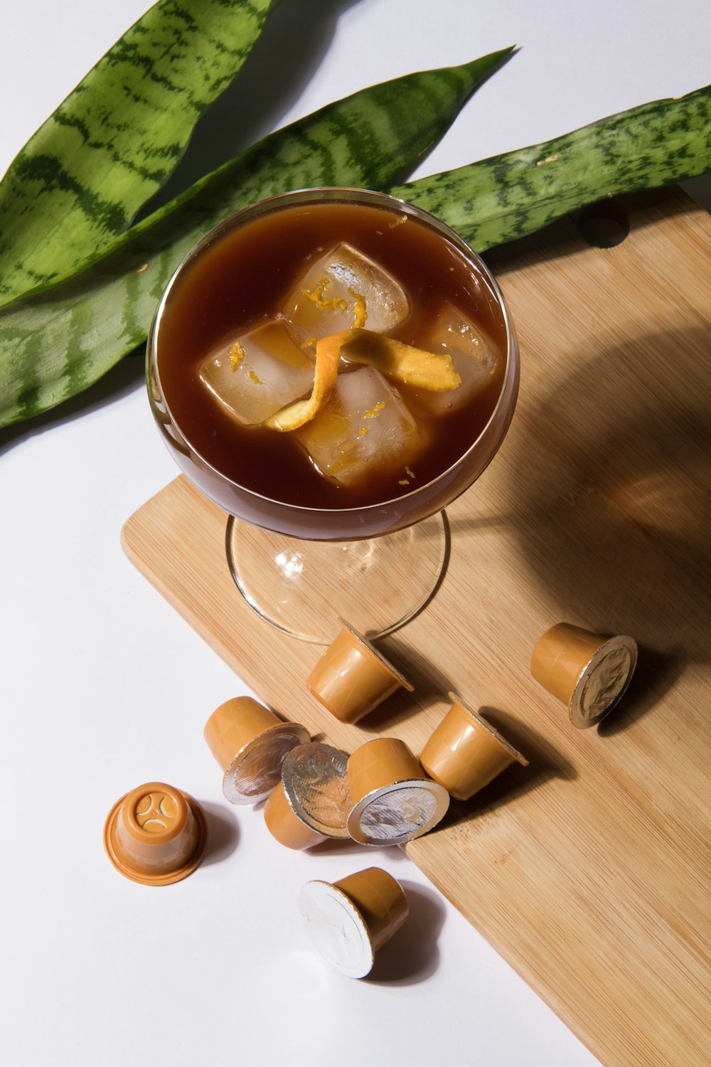 wine glass with brown liquid and ice cubes