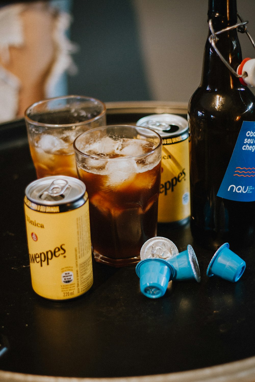 two yellow cans with drinking glasses on black table