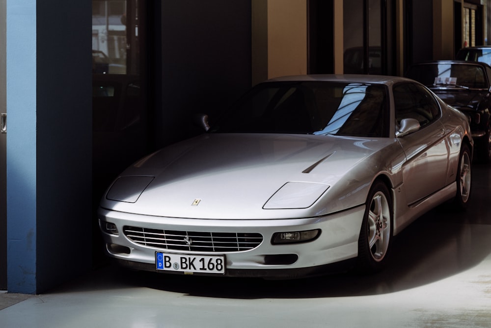 silver coupe on garage