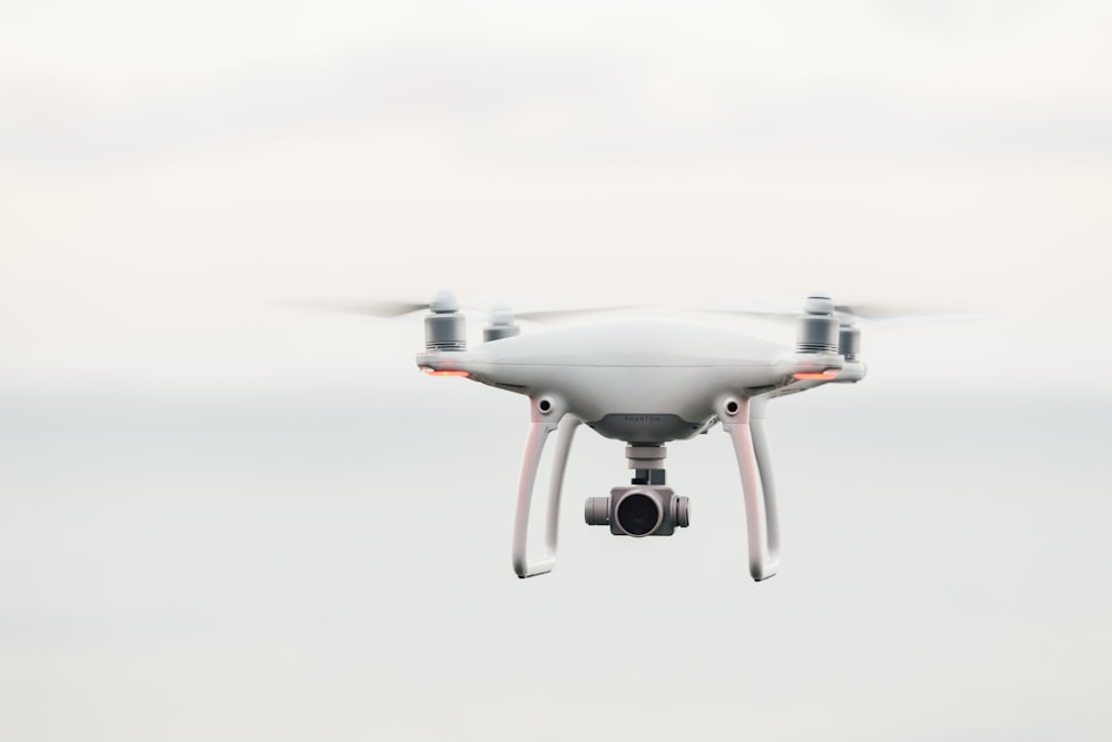 drone quadricóptero branco voando