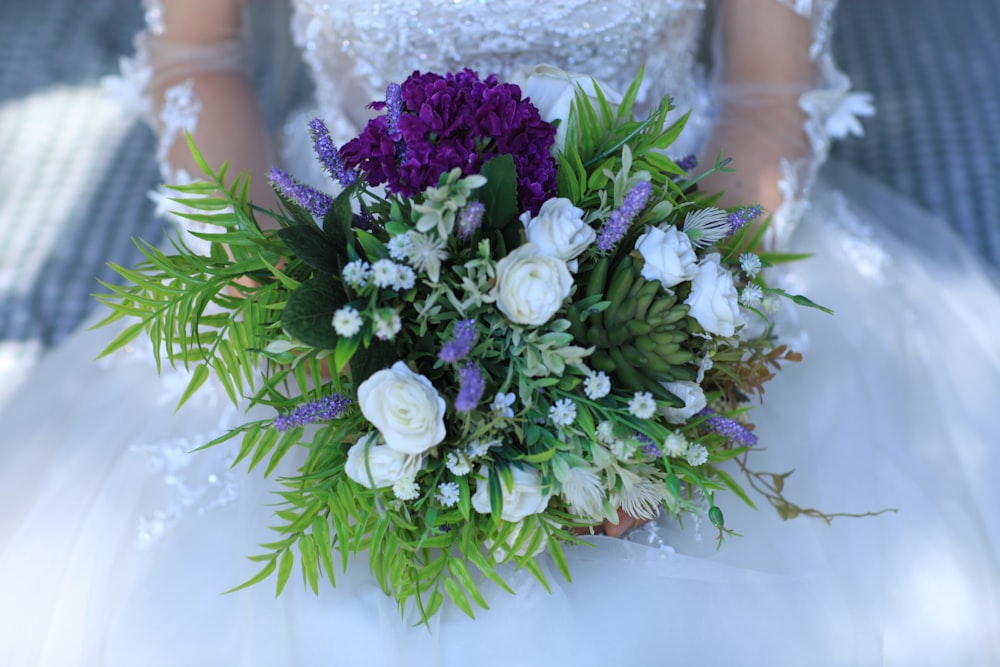 woman holding white and purple flower bouquet