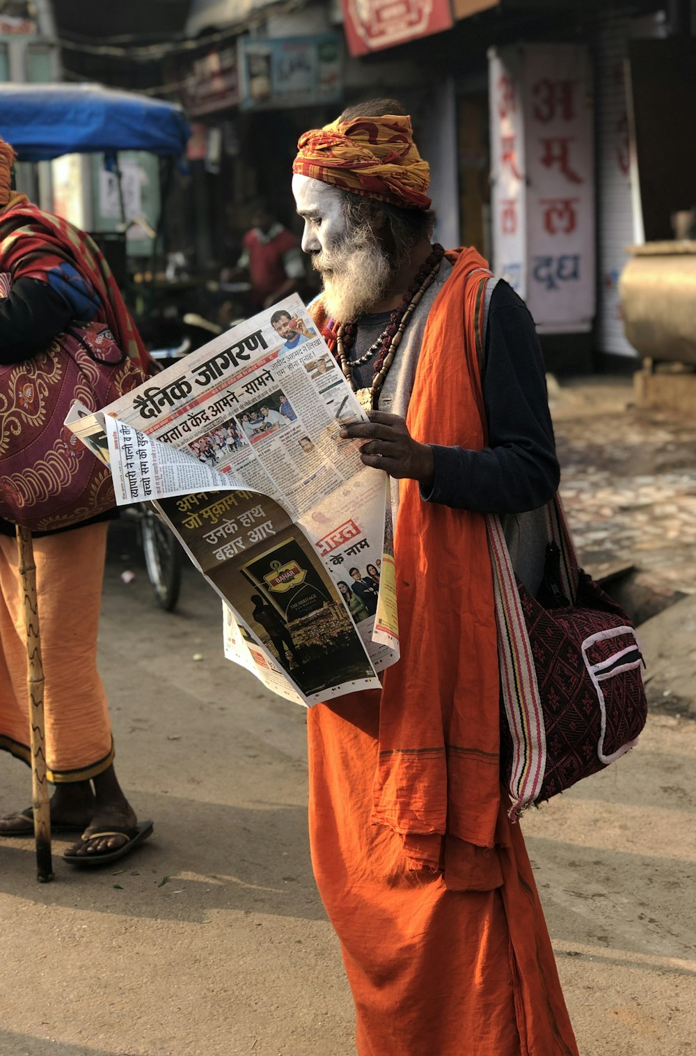 通りの脇で新聞を読む男
