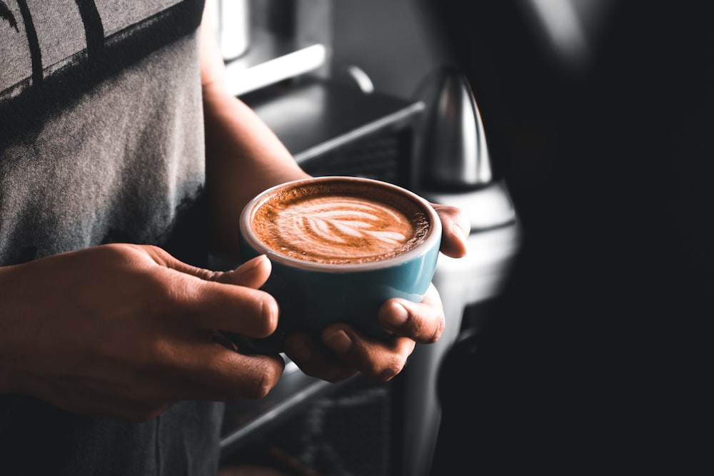 personne tenant une tasse de café photographie en gros plan