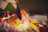A family joyfully placing their terracotta Ganpati idol on a decorated altar with marigold flowers.