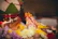 A family joyfully placing their terracotta Ganpati idol on a decorated altar with marigold flowers.
