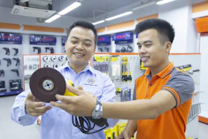 two men holding sander power tool