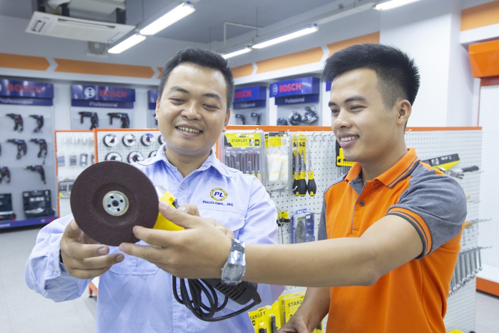 two men holding sander power tool