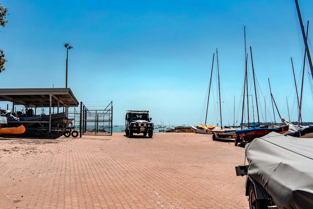 black SUV on docks near boats during daytime