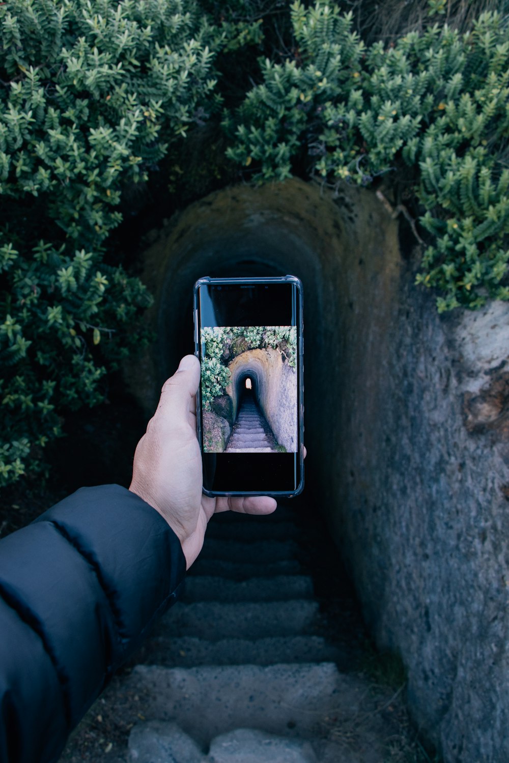 personne prenant une photo de la grotte en béton