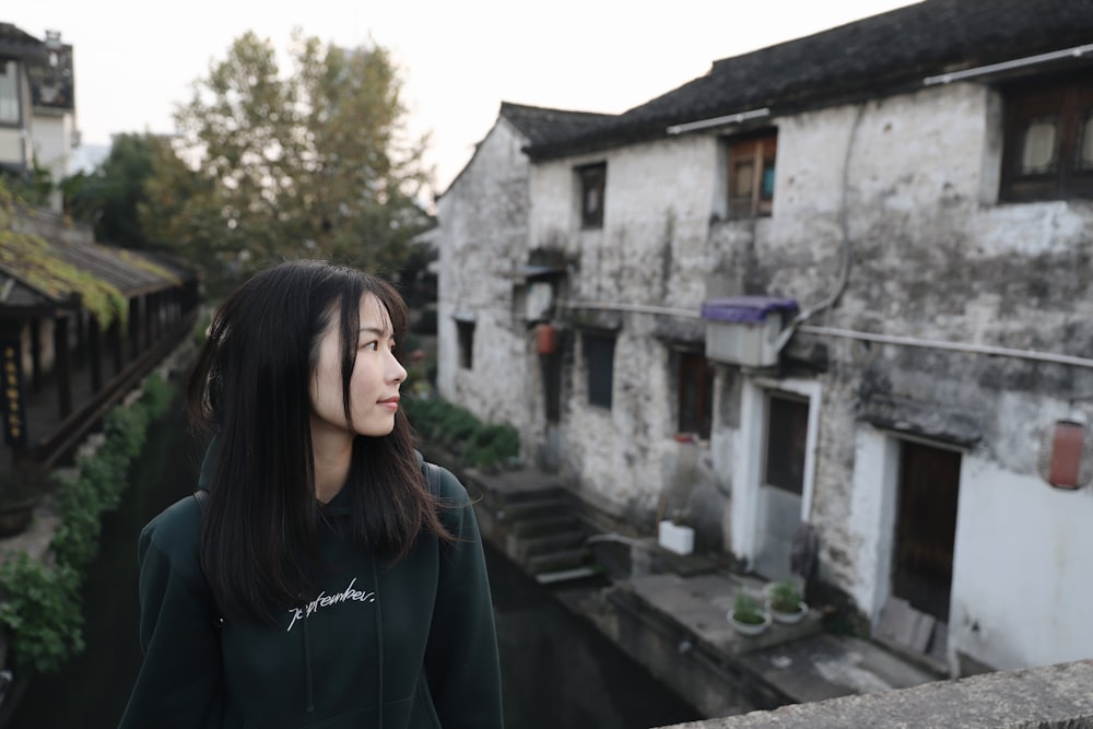 smiling woman wearing black crew-neck long sleeved shirt looking at the right side