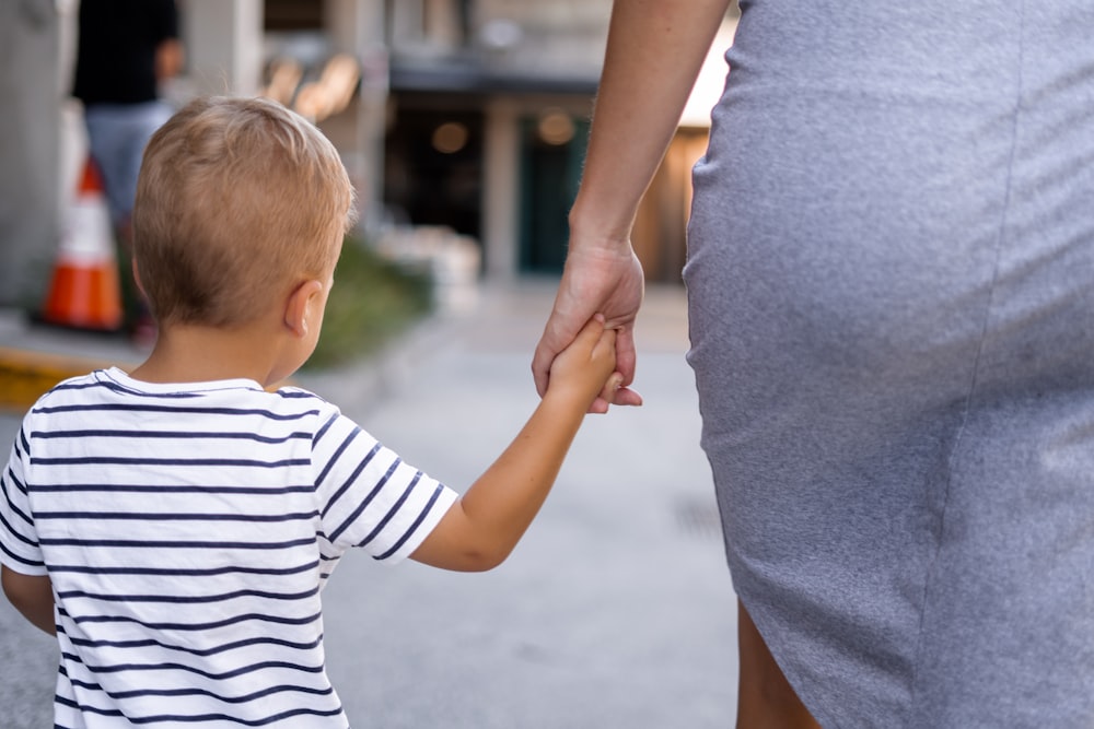 boy and woman holding hands outdoor