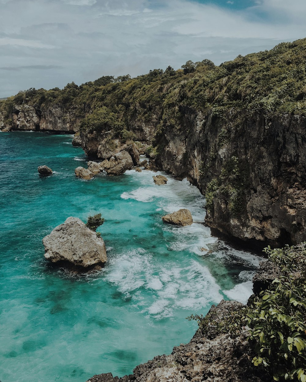 architectural photography of rock formation beside body of water