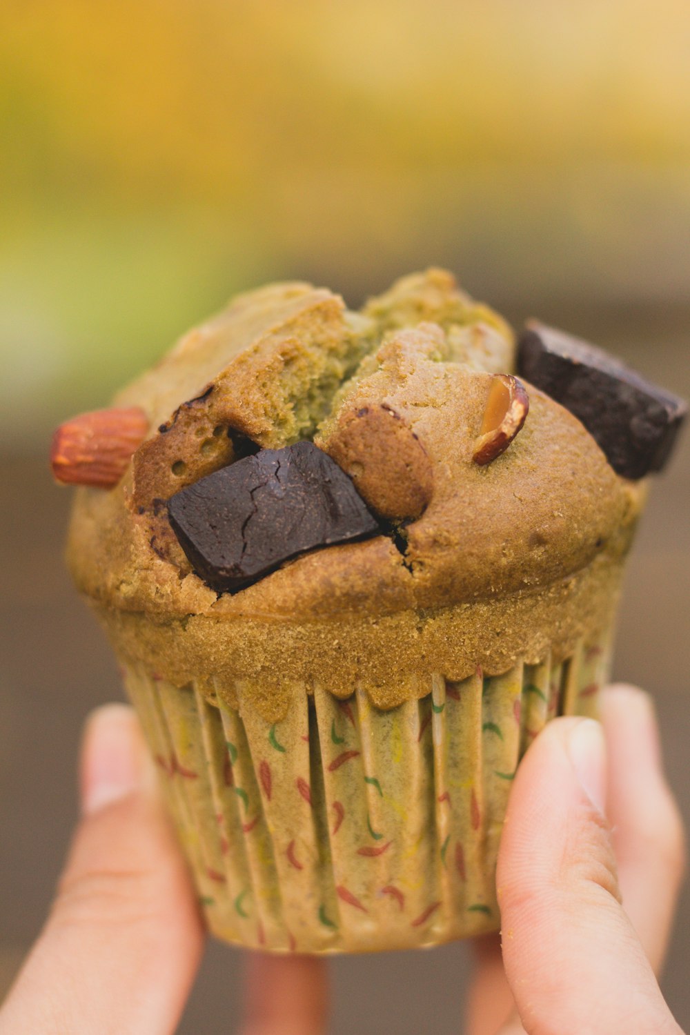 person holding brown cupcake