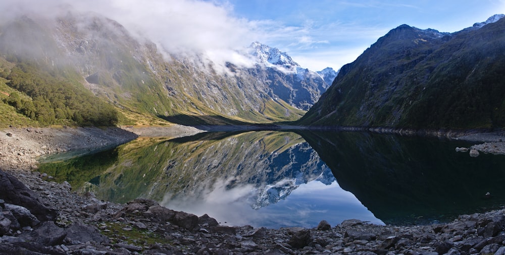 body of water surrounded by mountains during daytime