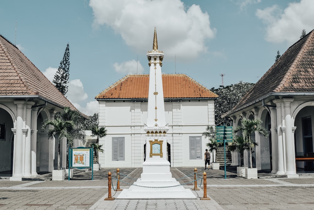 um edifício branco com uma torre do relógio à sua frente