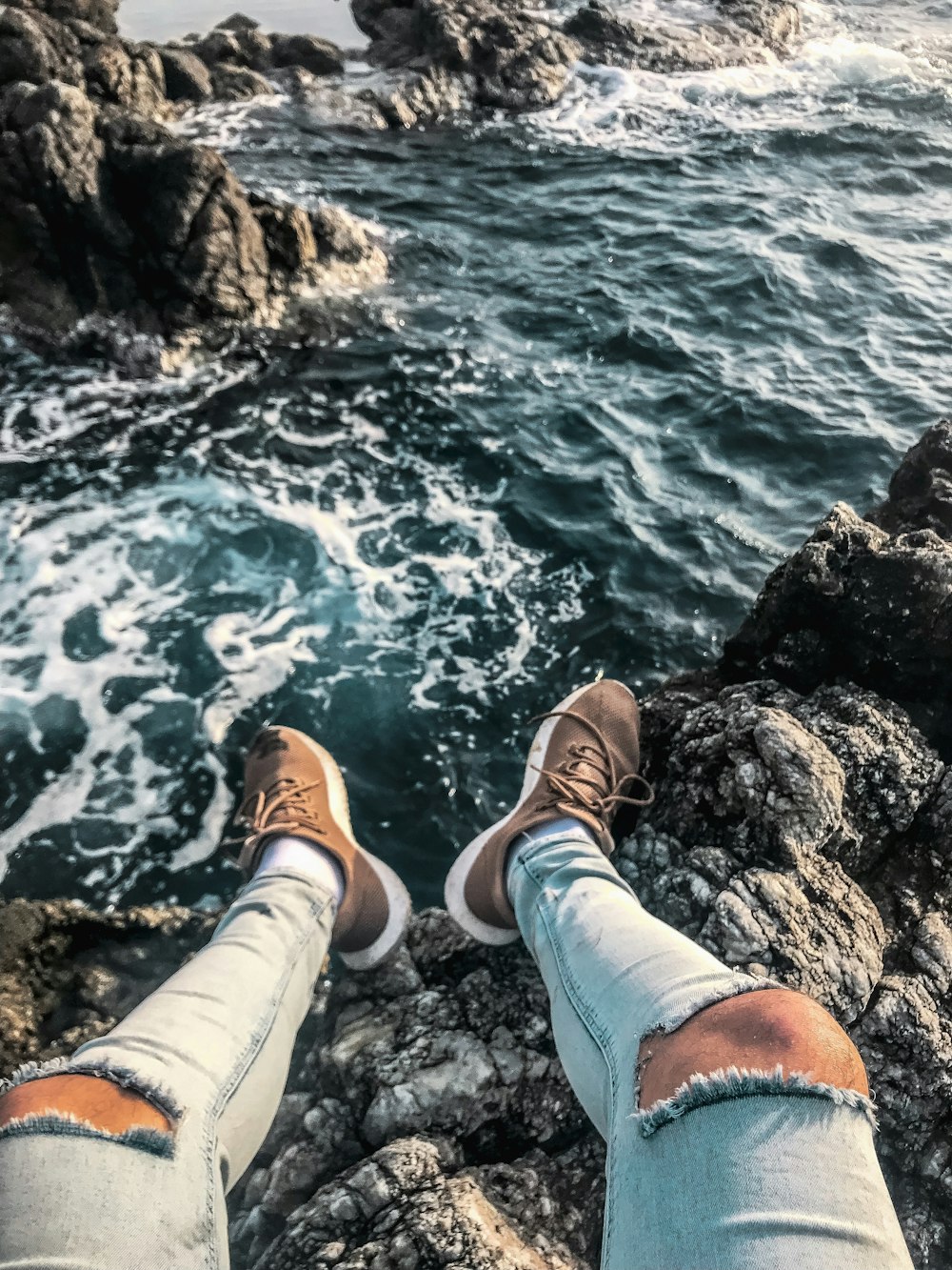 person sitting on high ground above body of water