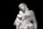 A marble statue of a mother embracing her child with a gentle, elegant posture.