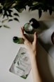 person touching black plastic bottle