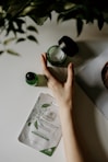person touching black plastic bottle