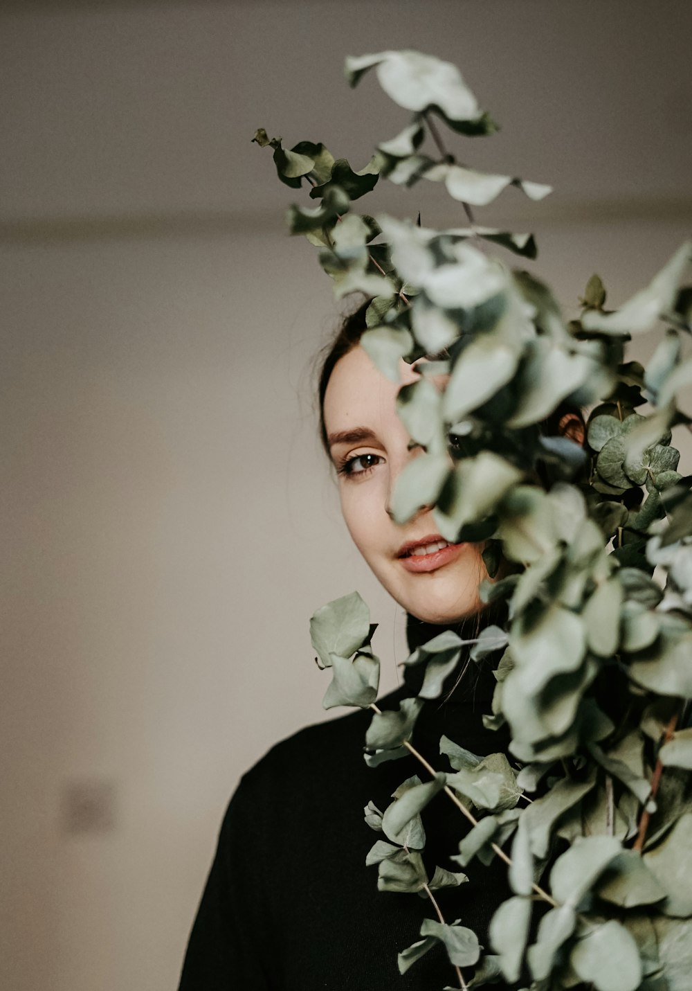 woman in black shirt in front of green plants