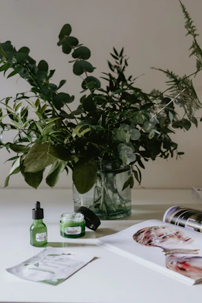 A serene morning scene with 澄光 collagen products arranged on a light wooden table beside fresh green leaves