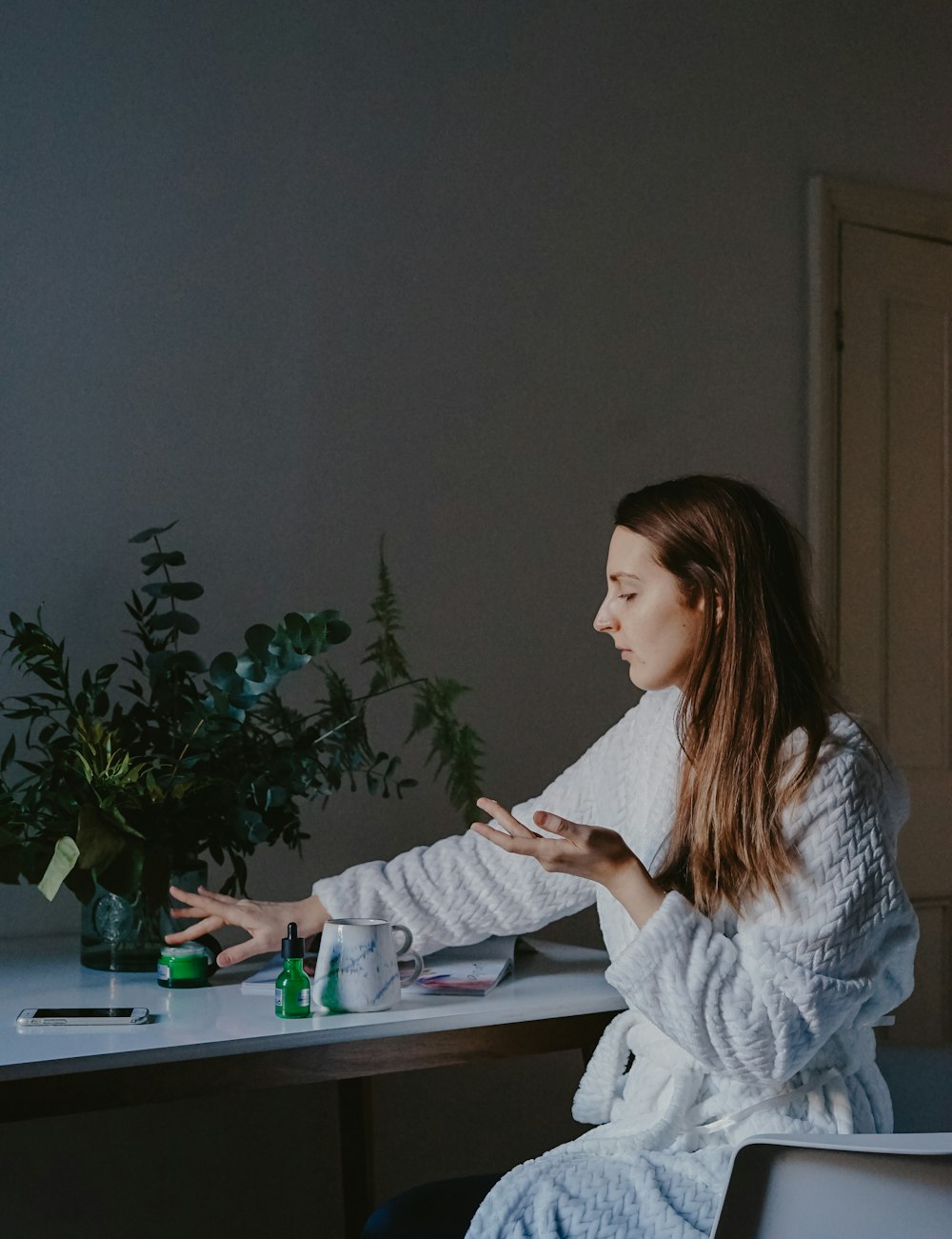 woman sitting at the table while grabbing green container