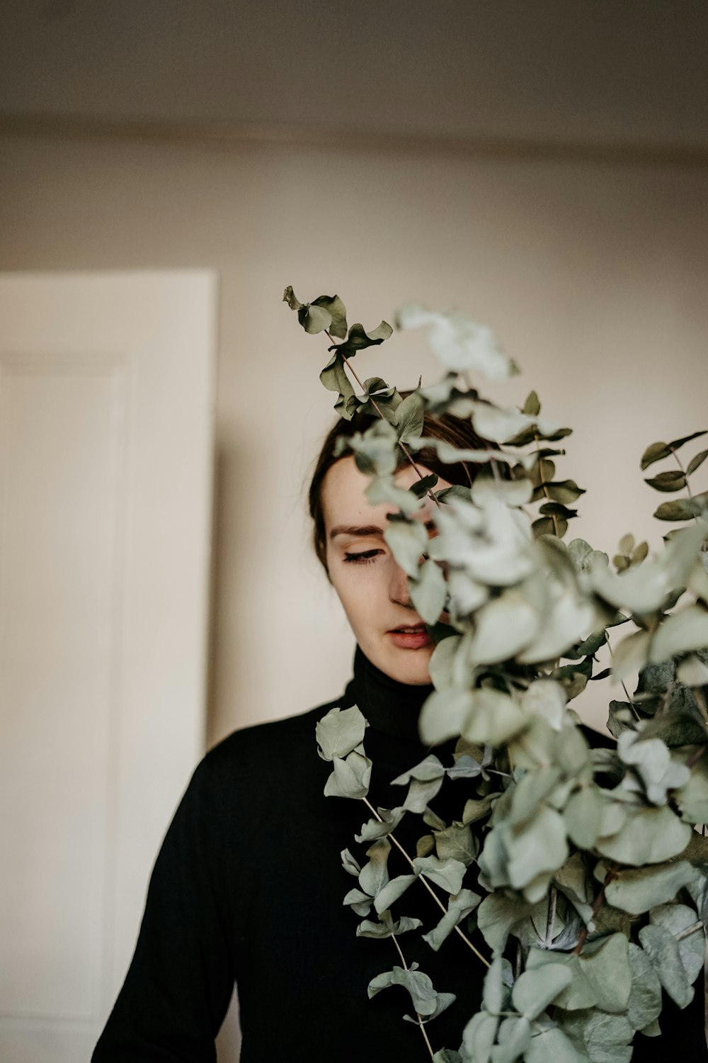 woman standing and hiding at green plant