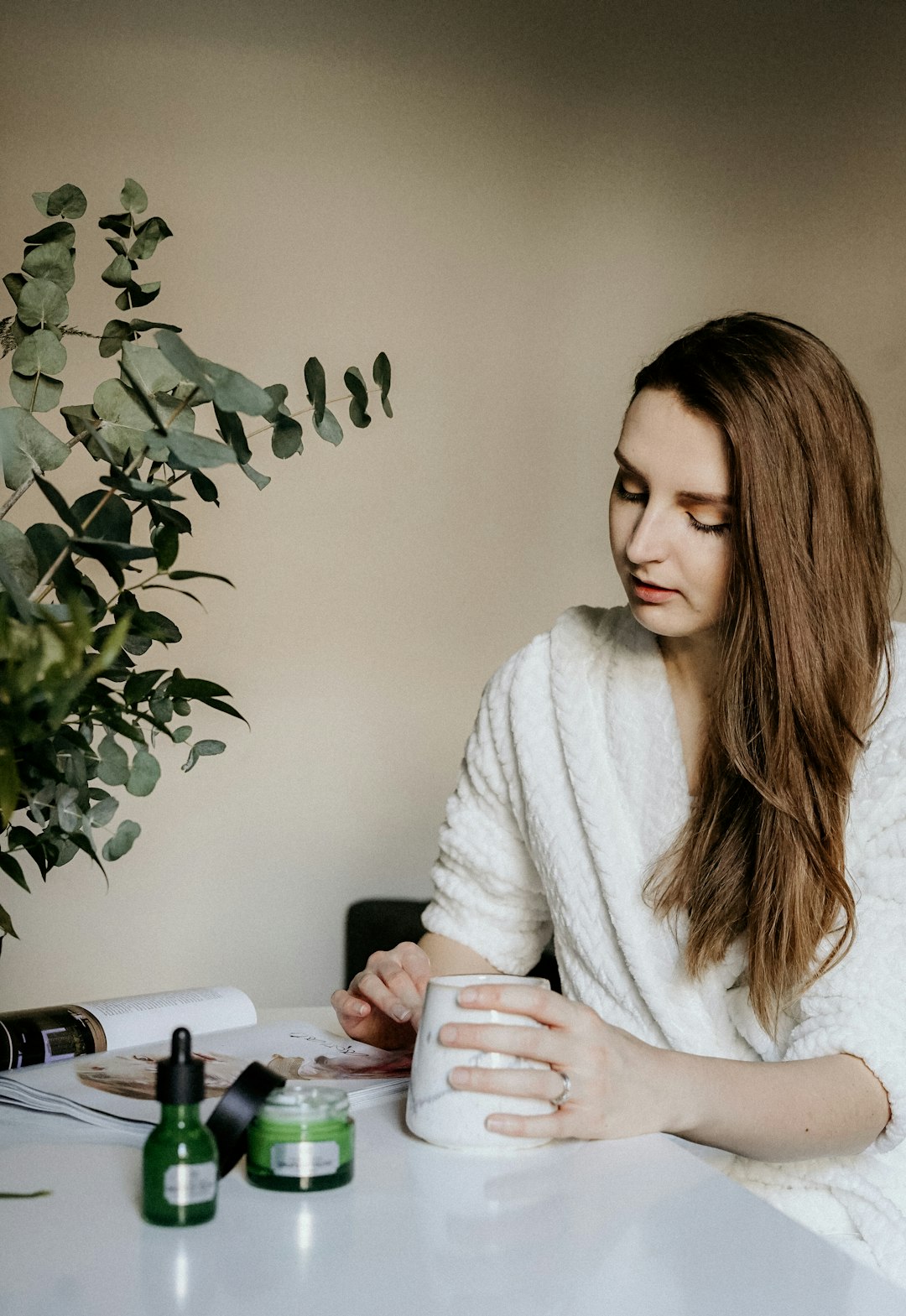 woman holding cup beside green plant