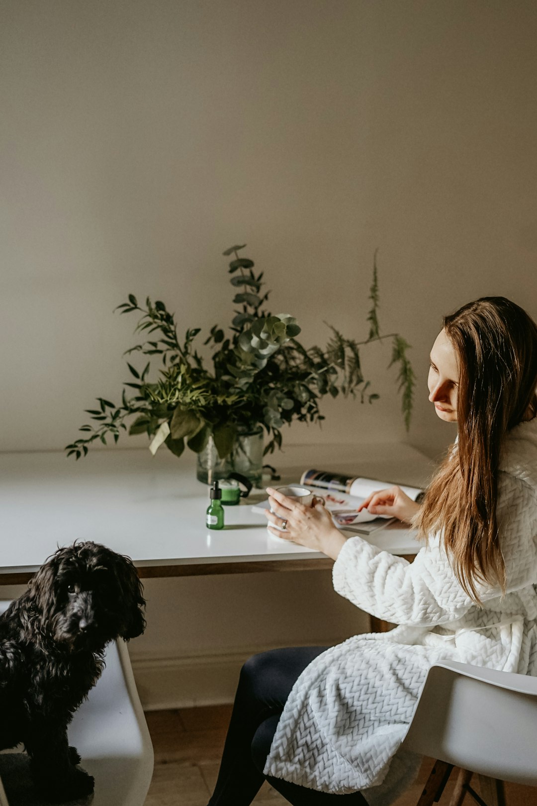 woman looking at her black curly-hair dog