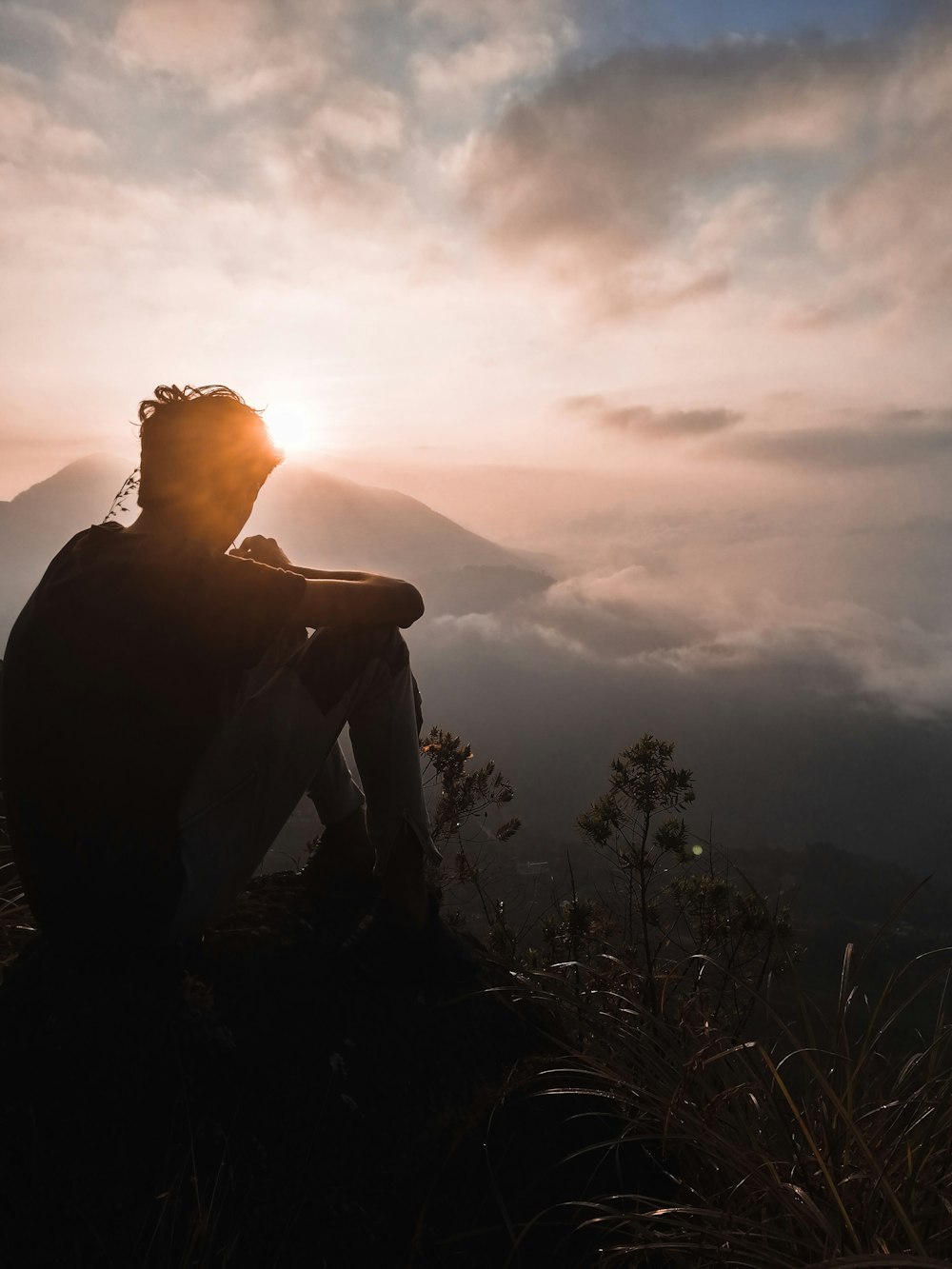 silhouette of man sitting during sunset