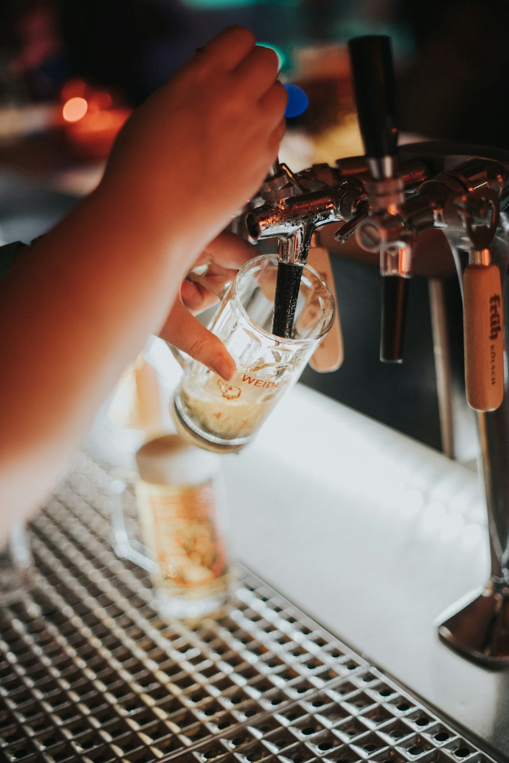 person pouring beer on glass