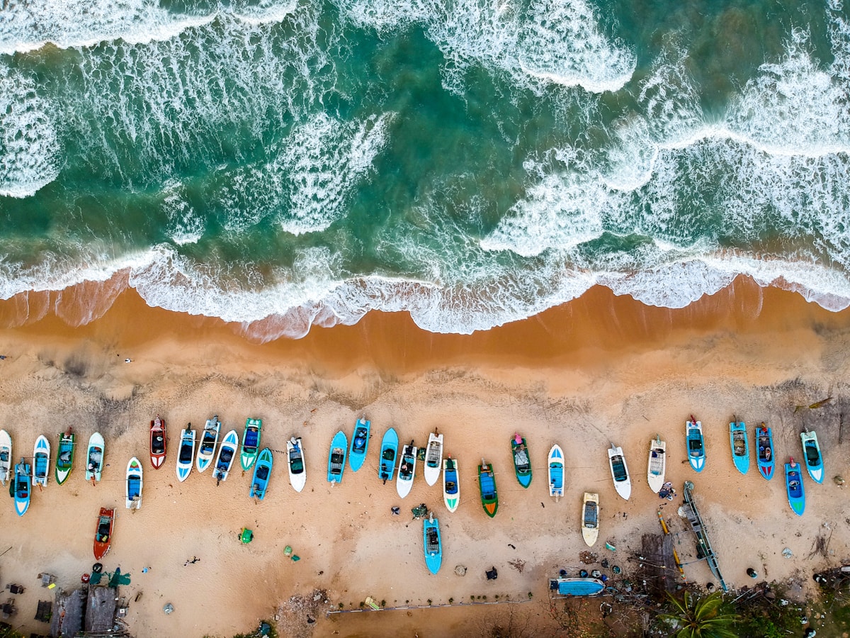 Colourful fishing boats lined up on the shore of Arugam Bay, Sri Lanka's famous surf beach on the east coast