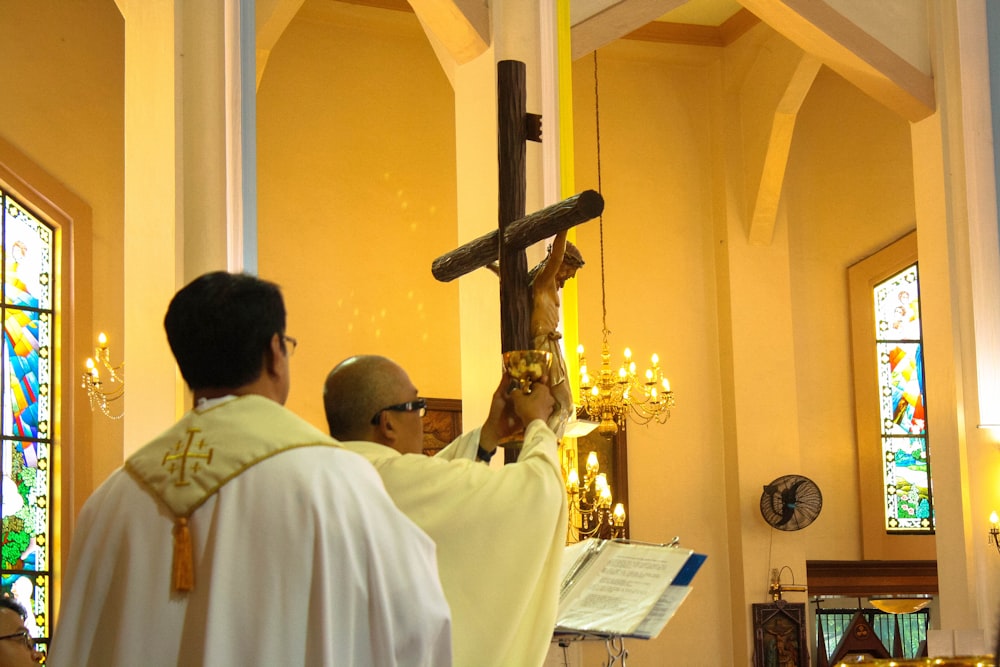 priest holding crucifix inside church