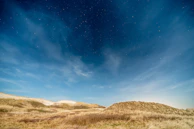 A starry night sky over the quiet natural landscape, inviting peaceful dreams.