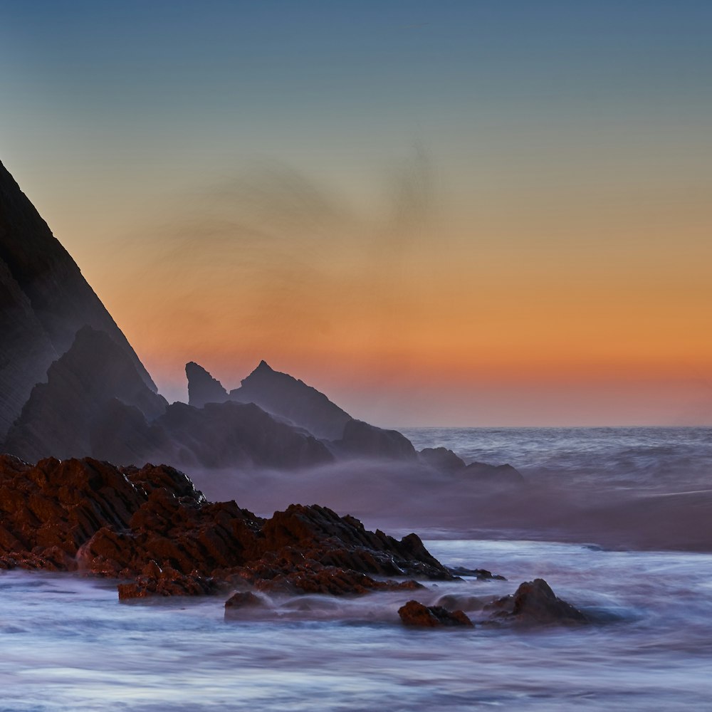 black mountain near body of water