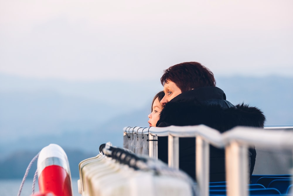 woman sitting beside girl near mountain