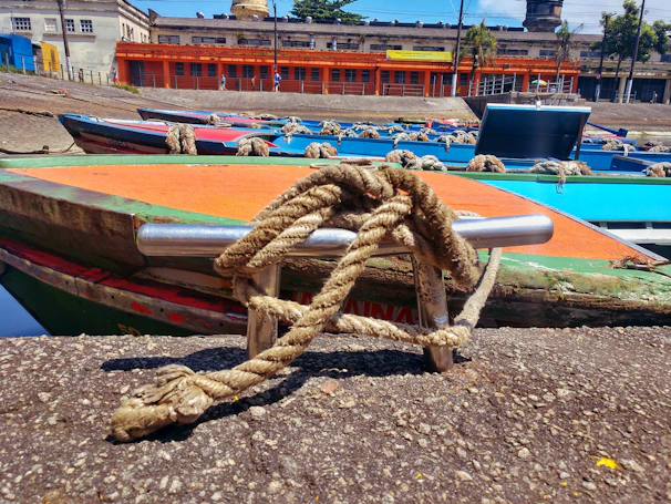 Wide shot of a busy quay wall lined with multiple marine bollards securing large mooring lines from docked vessels.