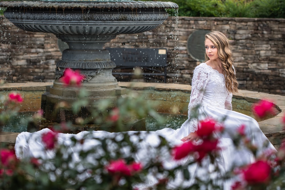 woman wearing wedding gown near fountain
