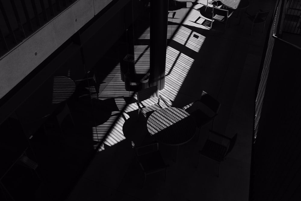 Ein Schwarz-Weiß-Foto von Stühlen und Tischen