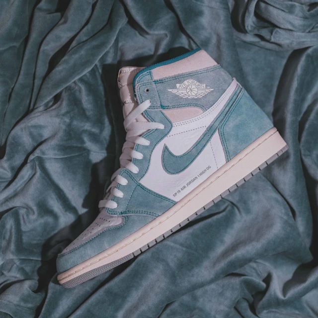 A single teal and grey Air Jordan 1 sneaker shown in profile