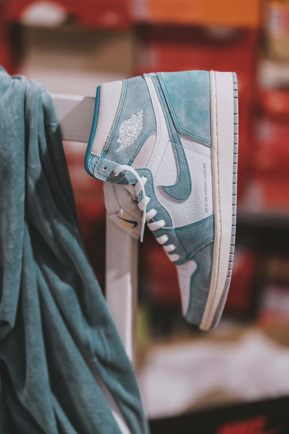 Air Jordan 1 blanco y gris sobre soporte de madera blanco