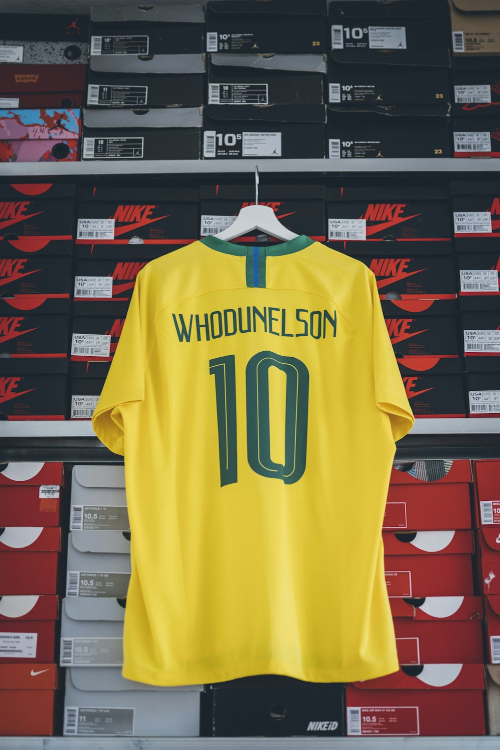 yellow Whodunelson 10 soccer jersey hanging on shoebox rack