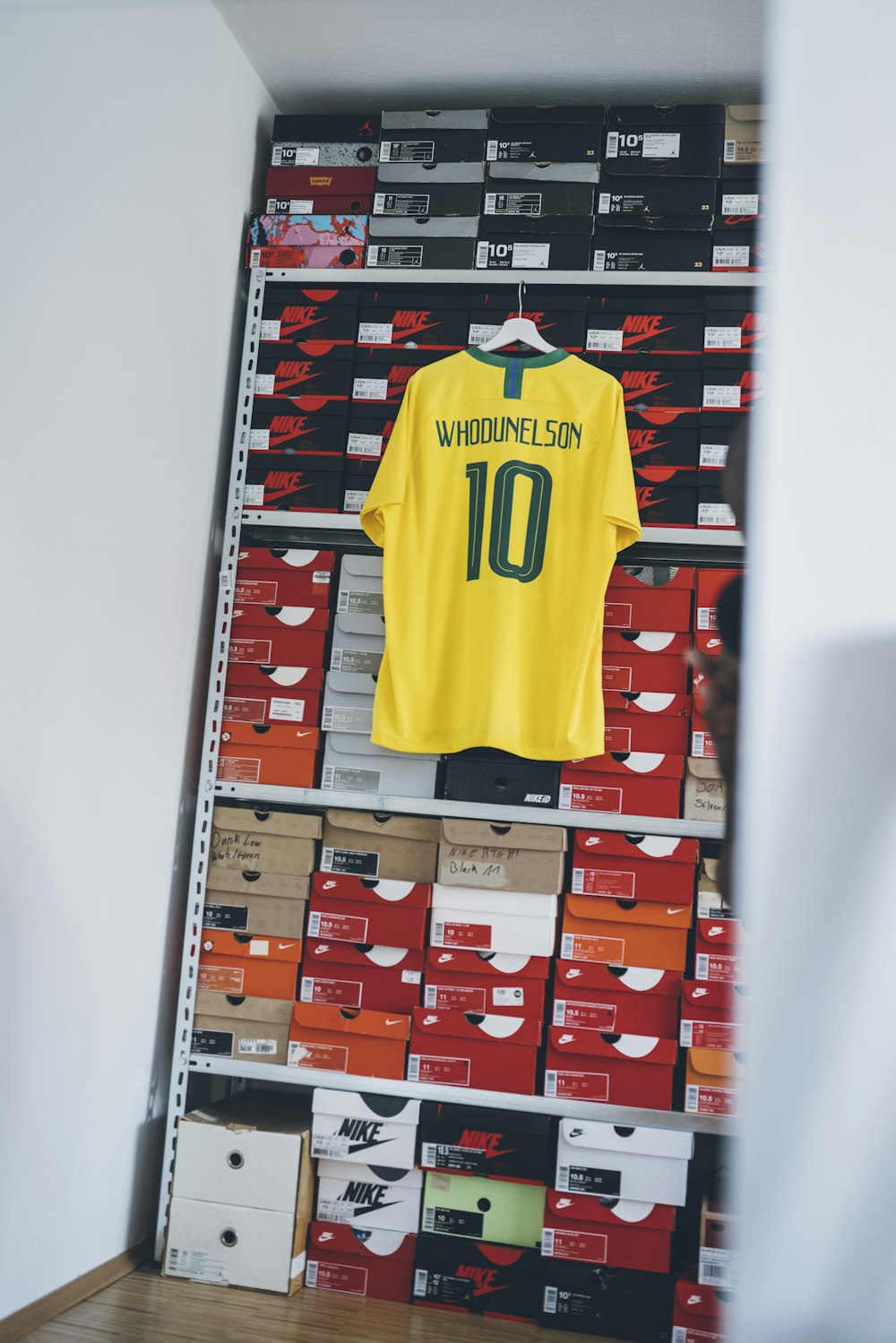 yellow and green Brazil soccer jersey hang beside shoe box