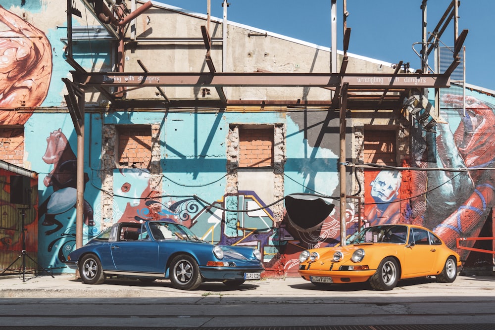 two blue and yellow cars parked beside building