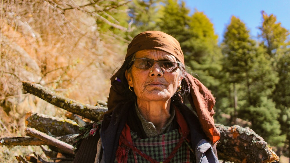 woman wearing gray hat in front of fallen tree during daytime