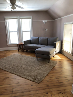 Bright living room with light wood furniture and soft gray textiles.