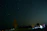 A serene night sky filled with twinkling stars over a quiet Indian village.