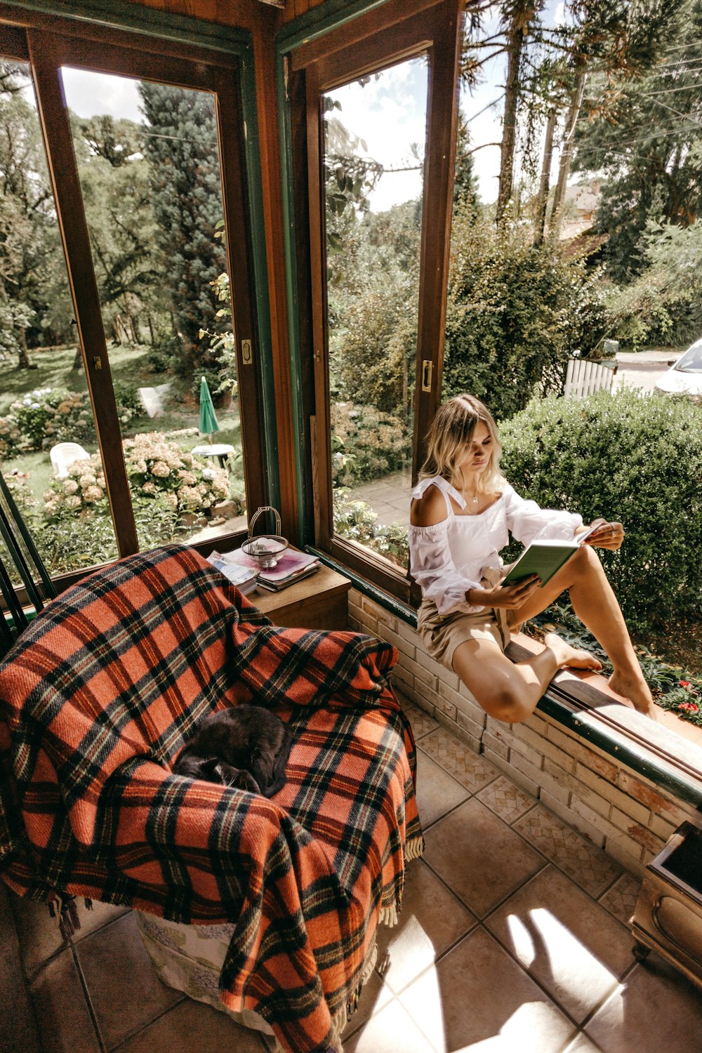 woman sitting on window beside sofa