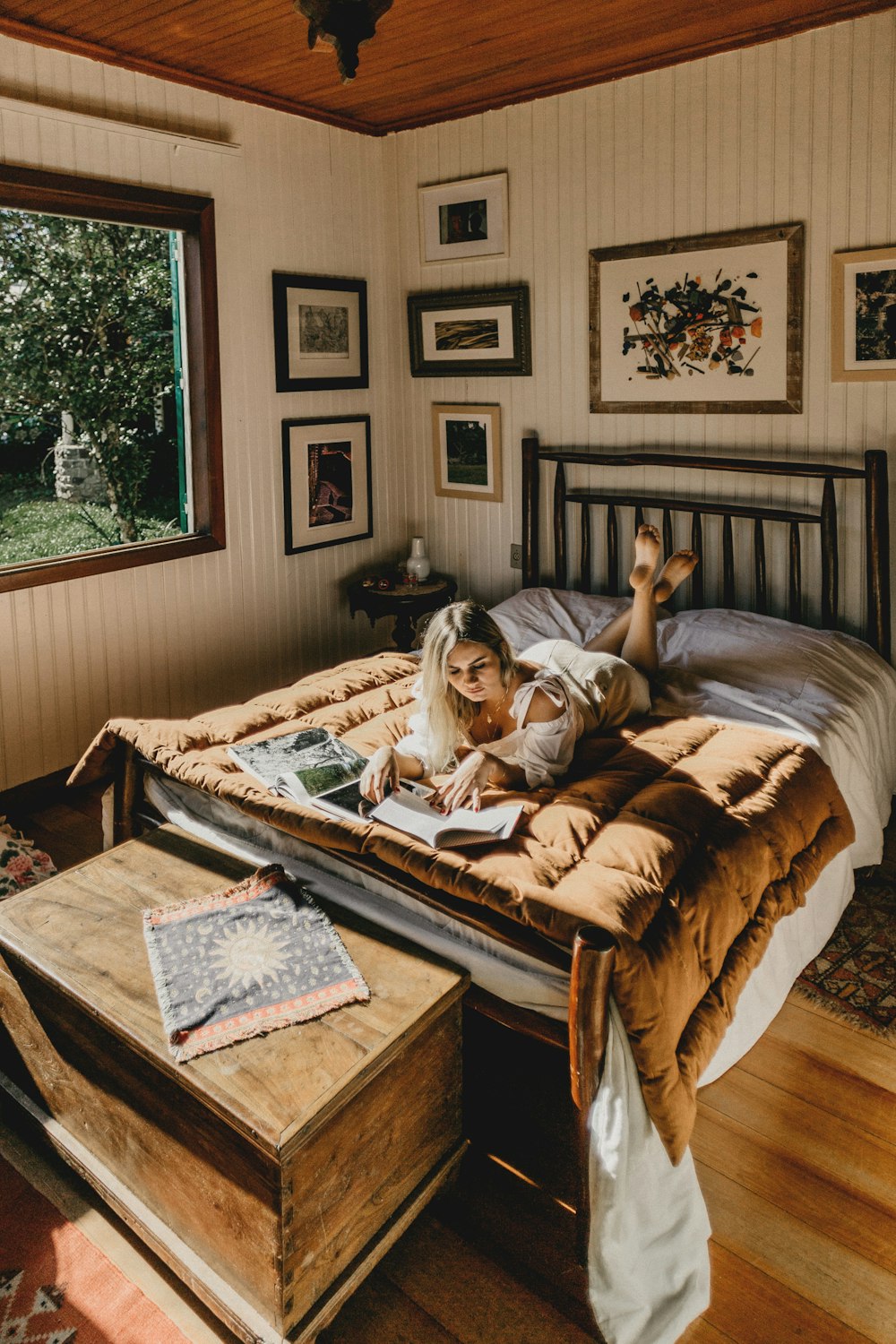 Frau liegt auf dem Bett, während sie ein Buch liest